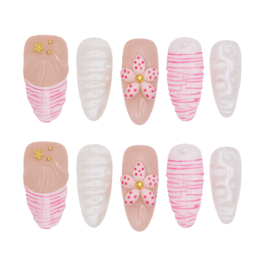 Set of decorative press-on nails with pink and white designs on a white background